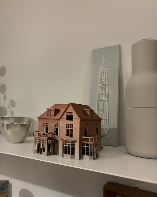 Kopergekleurd huis op een plank