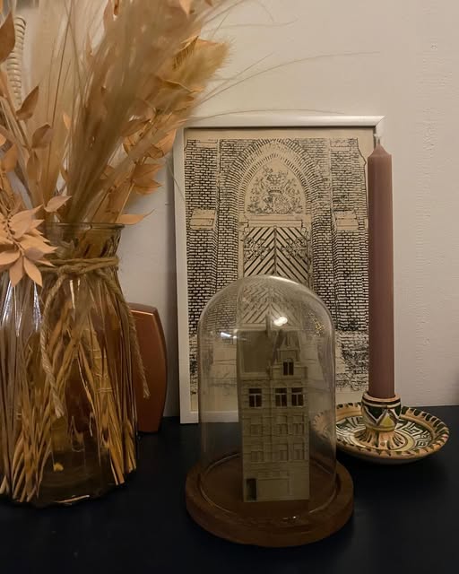 Huis onder een glazen stolp met gedroogde bloemen