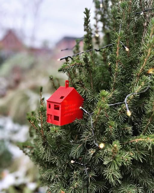 Rood huisje in een buitenboom met lichtjes